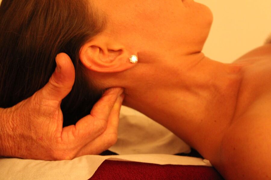 Roger's hand supporting a client's neck during a relaxing massage
