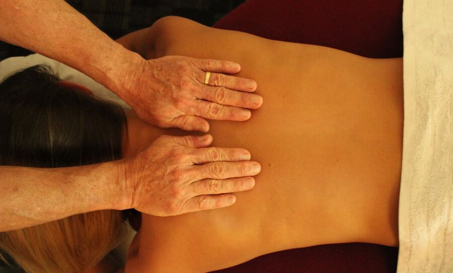 Roger's hands working along a client's back